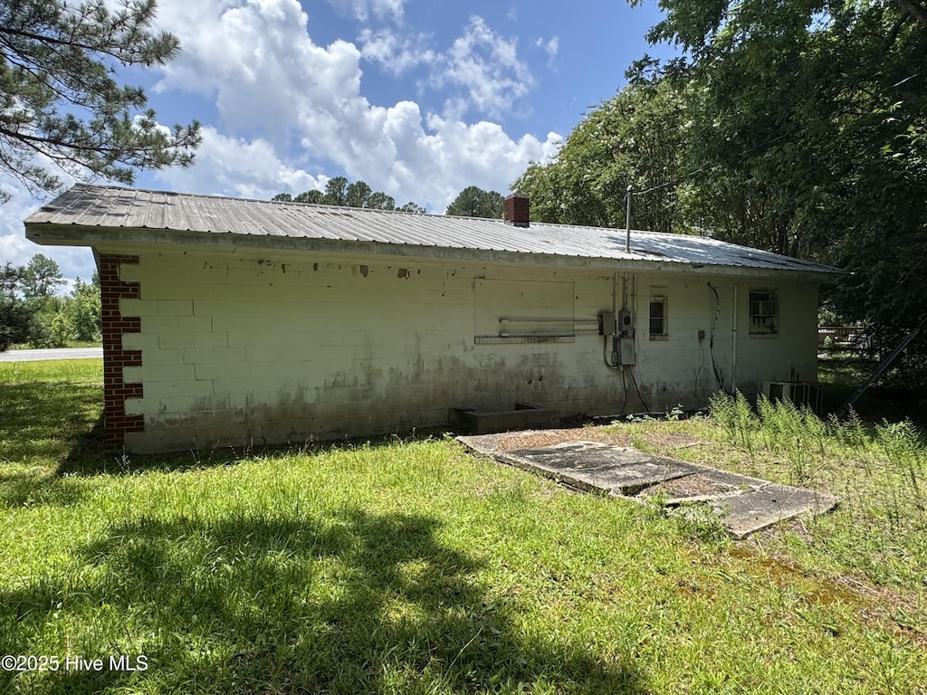 11085 Sam Potts Hwy, Lake Waccamaw, NC 28450 - rear view of property featuring concrete block siding, a yard, and a metal roof