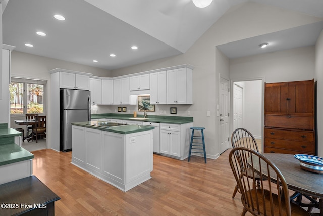 8 Driving Range Rd, Pinehurst, NC 28374 - kitchen featuring freestanding refrigerator, dark countertops, black electric stovetop, light wood finished floors, and white cabinetry