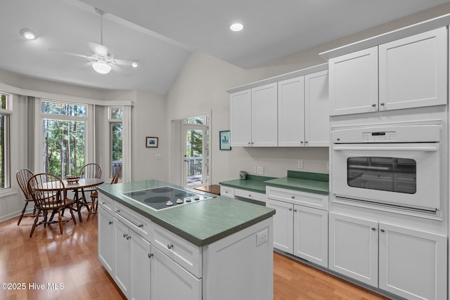 8 Driving Range Rd, Pinehurst, NC 28374 - kitchen with white oven, black electric cooktop, lofted ceiling, a ceiling fan, and plenty of natural light