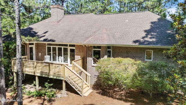 8 Driving Range Rd, Pinehurst, NC 28374 - view of front facade featuring roof with shingles, a chimney, a deck, and brick siding
