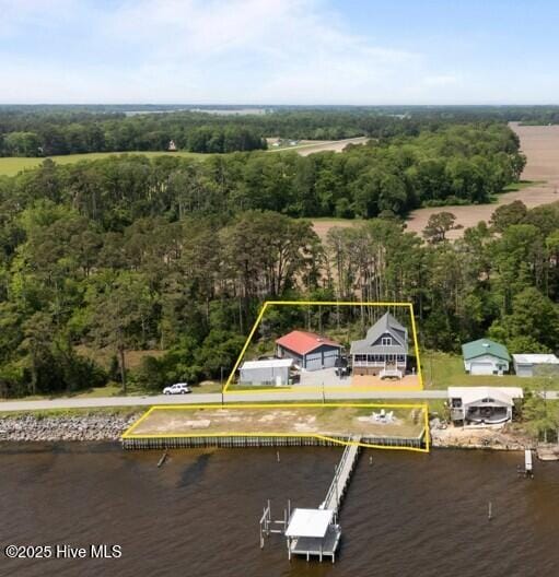 view of property location with a large body of water, property boundaries highlighted, and a forest