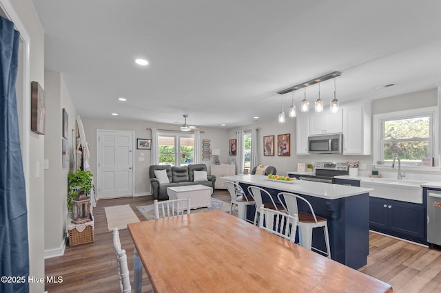 dining area with baseboards, wood finished floors, visible vents, and recessed lighting
