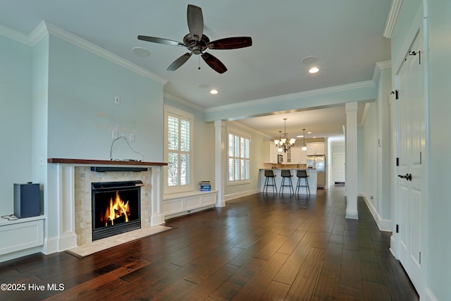 6445 Figure Eight Dr SW, Ocean Isle Beach, NC 28469 - unfurnished living room featuring a fireplace, a chandelier, dark wood-style flooring, ceiling fan, and crown molding