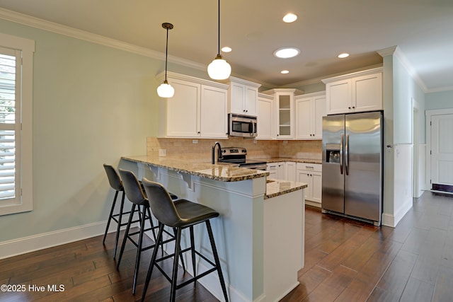 6445 Figure Eight Dr SW, Ocean Isle Beach, NC 28469 - kitchen featuring stainless steel appliances, crown molding, a peninsula, glass insert cabinets, and white cabinetry