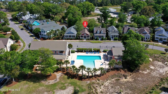 6445 Figure Eight Dr SW, Ocean Isle Beach, NC 28469 - aerial view of property and surrounding area featuring a pool area, nearby suburban area, and a tree filled landscape
