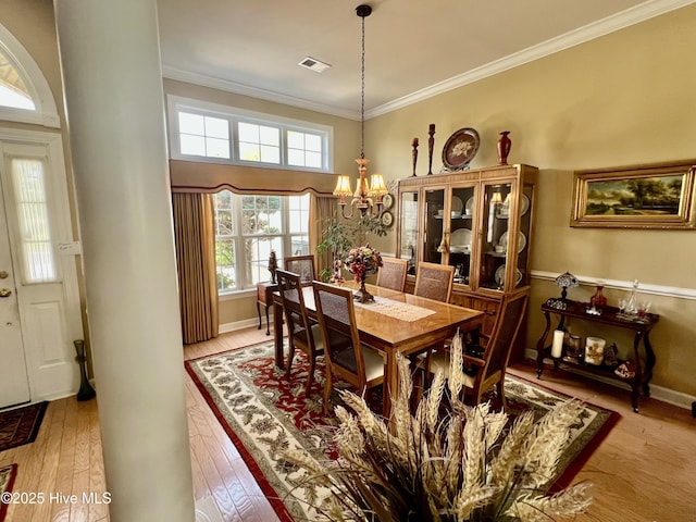 7473 Balmore Dr SW, Sunset Beach, NC 28468 - dining room featuring a chandelier, ornamental molding, and light wood finished floors