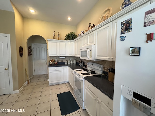 7473 Balmore Dr SW, Sunset Beach, NC 28468 - kitchen featuring white appliances, light tile patterned flooring, dark countertops, backsplash, and white cabinetry