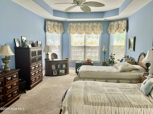 7473 Balmore Dr SW, Sunset Beach, NC 28468 - carpeted bedroom with a raised ceiling, multiple windows, and ceiling fan
