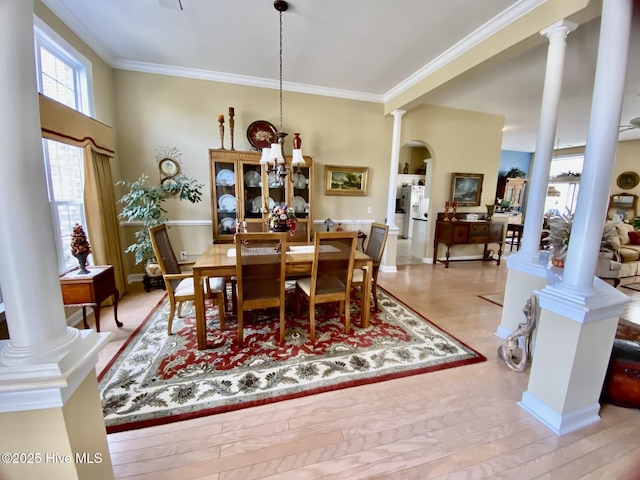 7473 Balmore Dr SW, Sunset Beach, NC 28468 - dining area featuring decorative columns, ornamental molding, arched walkways, and wood finished floors
