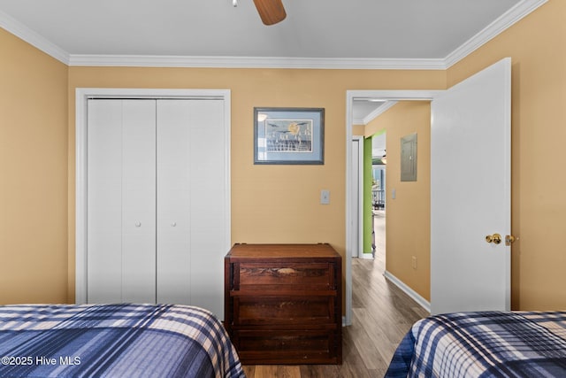 2714 W Beach Dr # 104, Oak Island, NC 28465 - bedroom with electric panel, baseboards, wood finished floors, a closet, and crown molding