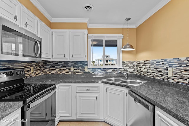 2714 W Beach Dr # 104, Oak Island, NC 28465 - kitchen featuring stainless steel appliances, dark countertops, visible vents, a sink, and white cabinetry