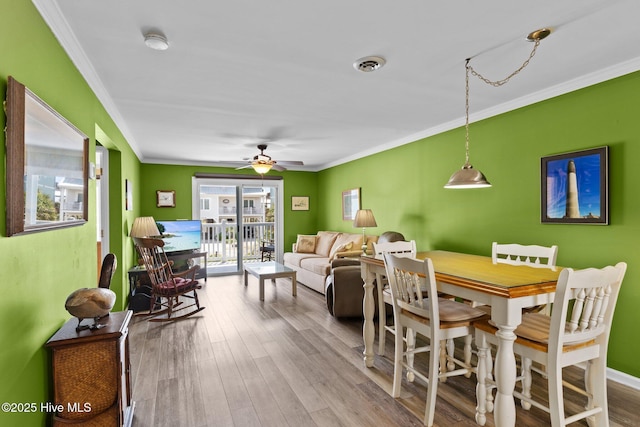 2714 W Beach Dr # 104, Oak Island, NC 28465 - dining space featuring ceiling fan, wood finished floors, and ornamental molding