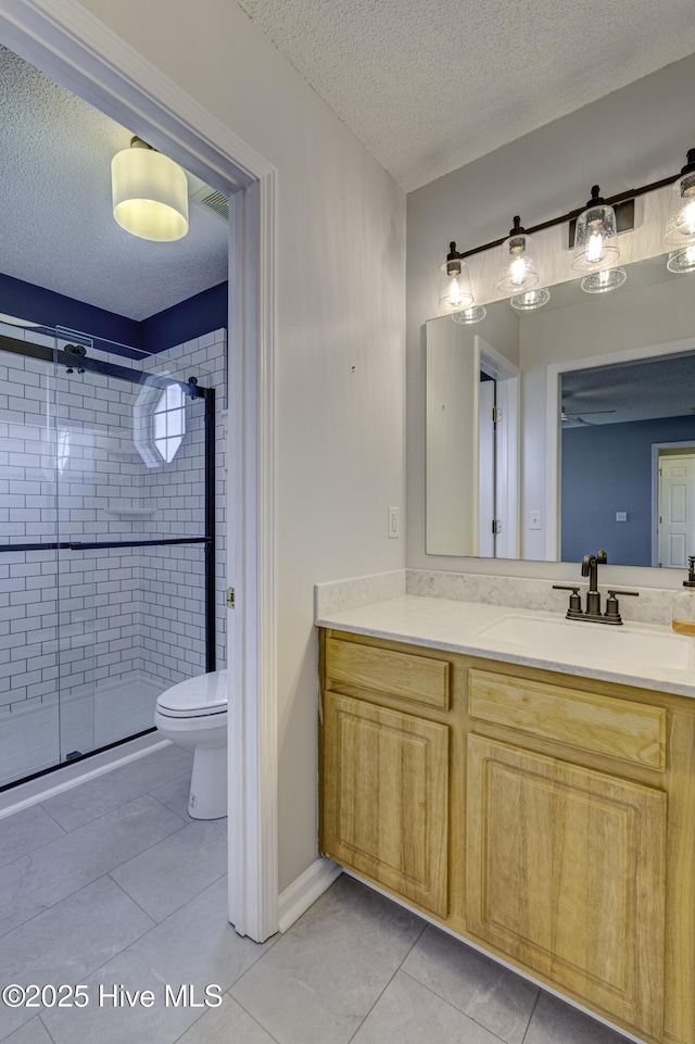 bathroom with tile patterned flooring, a textured ceiling, and a stall shower