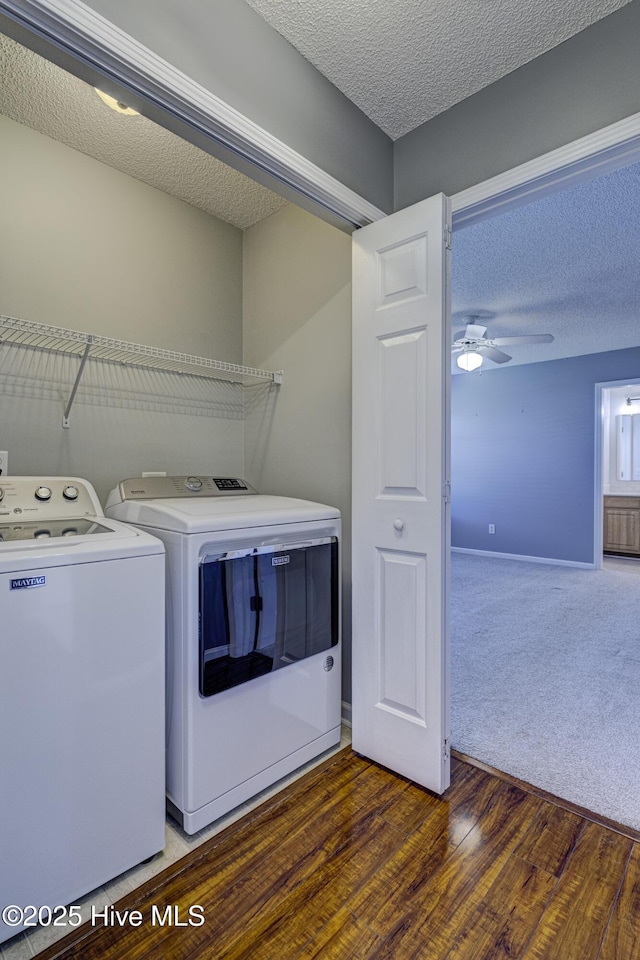 clothes washing area with independent washer and dryer, laundry area, ceiling fan, a textured ceiling, and wood finished floors