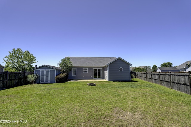 rear view of property with a fenced backyard, a yard, a patio area, a storage shed, and an outbuilding