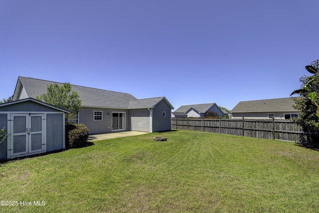 view of yard featuring fence, an outbuilding, a shed, and a patio area