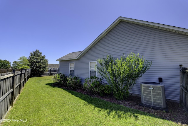 view of side of property with a lawn, a fenced backyard, and cooling unit