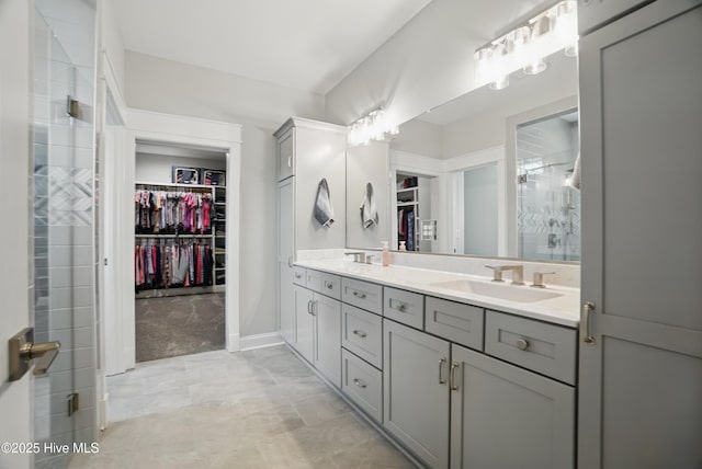 full bath featuring double vanity, a sink, a spacious closet, and a shower stall