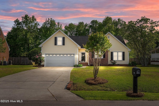 traditional-style house featuring a garage, a front lawn, fence, and driveway