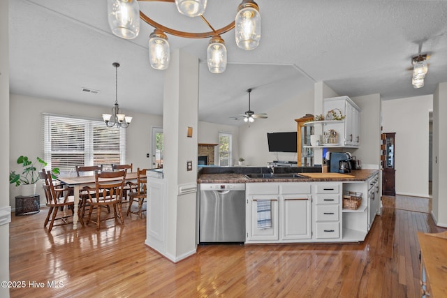 kitchen featuring open shelves, dishwasher, ceiling fan with notable chandelier, light wood-type flooring, and visible vents