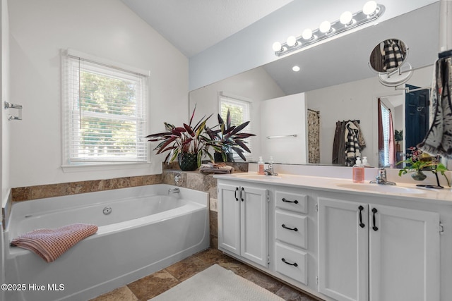 508 Commons Way, Wilmington, NC 28409 - bathroom featuring vaulted ceiling, double vanity, a bath, and stone finish floors