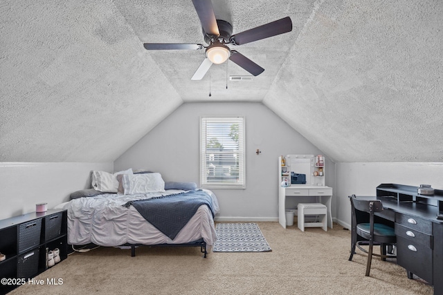 carpeted bedroom featuring ceiling fan, vaulted ceiling, a textured ceiling, and visible vents