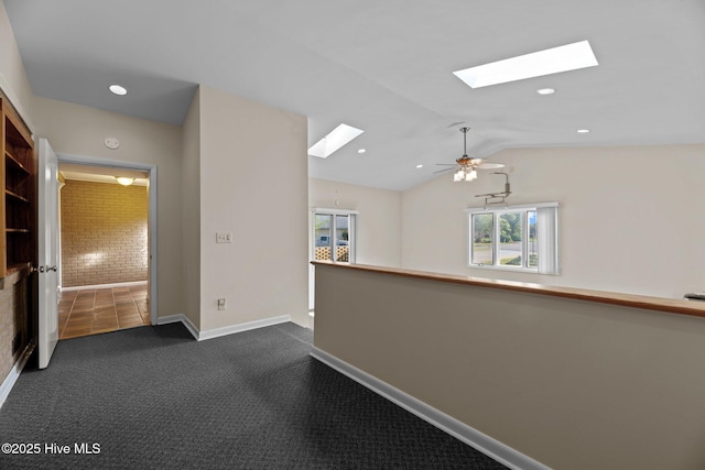 hall with recessed lighting, baseboards, dark carpet, and lofted ceiling with skylight