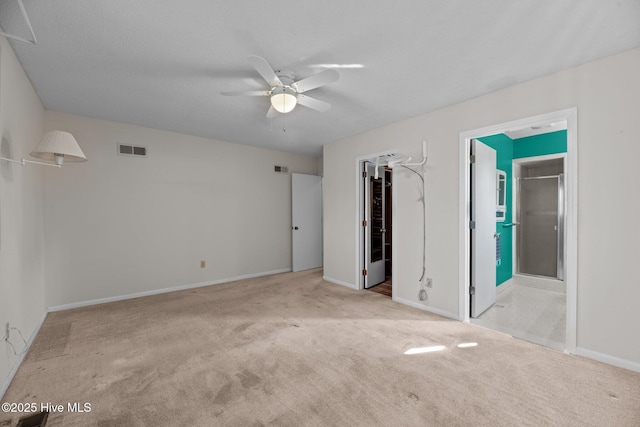 unfurnished bedroom featuring a spacious closet, baseboards, carpet, and visible vents