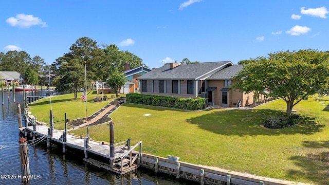 back of house featuring a lawn and a water view
