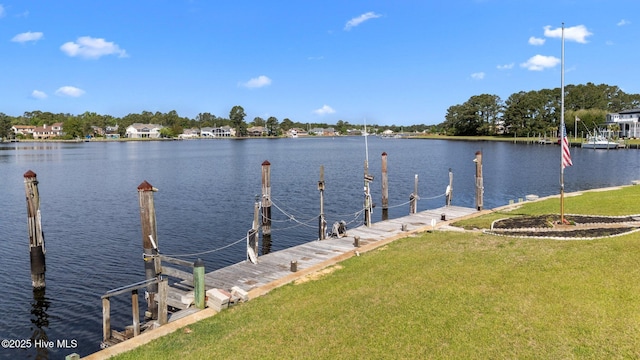 view of dock featuring a lawn and a water view