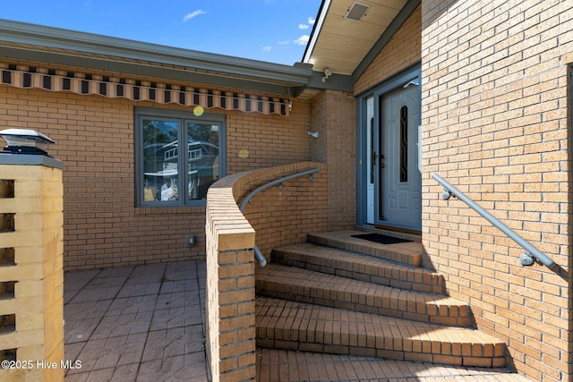 doorway to property with brick siding