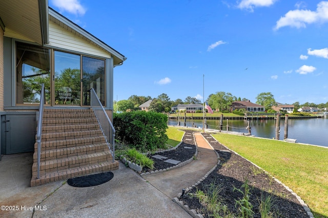 view of yard with a residential view, stairs, and a water view
