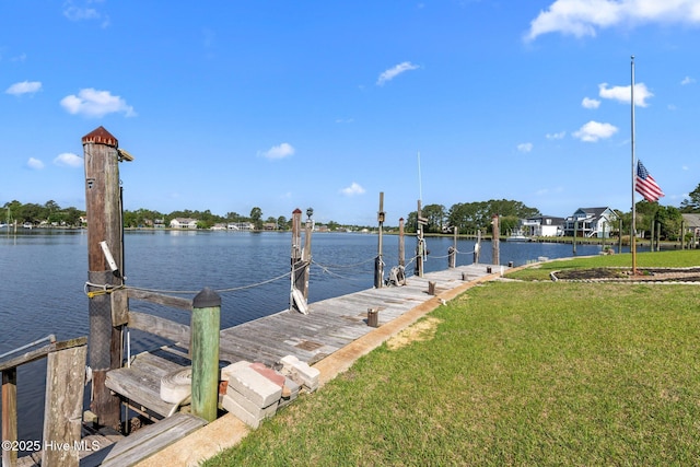 view of dock with a water view and a yard