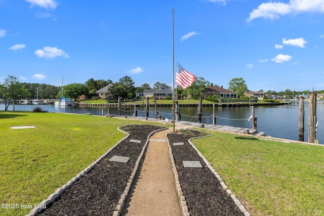 exterior space with a lawn, a water view, and a dock