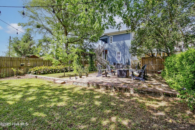 view of yard featuring stairway, a patio area, and a fire pit