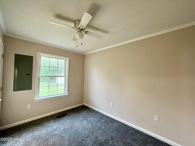 empty room featuring a ceiling fan, crown molding, electric panel, baseboards, and dark colored carpet
