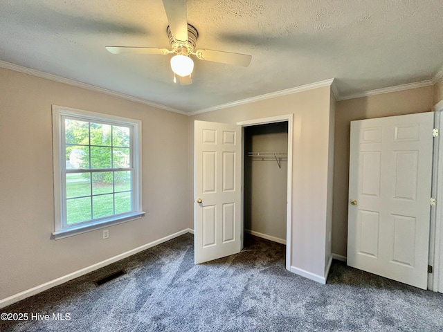 unfurnished bedroom featuring crown molding, carpet flooring, visible vents, and a closet
