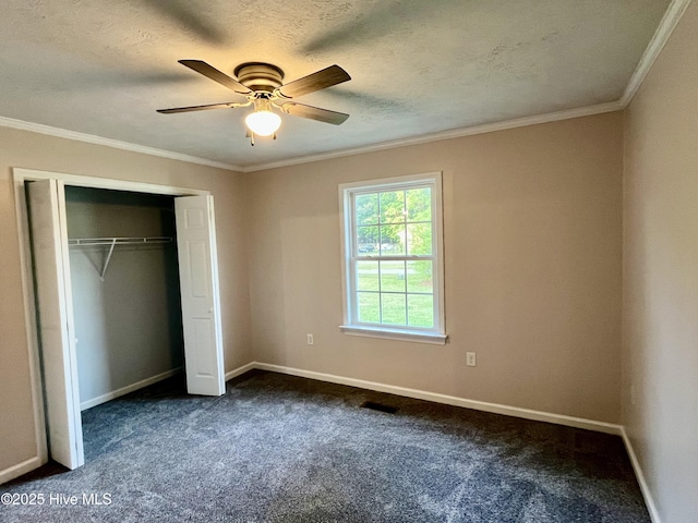 unfurnished bedroom with dark carpet, baseboards, crown molding, and visible vents