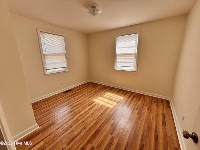 1010 Warren St, Clinton, NC 28328 - empty room featuring plenty of natural light, baseboards, and wood finished floors