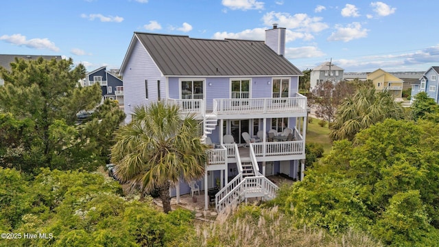105 Island Quay Ct, Atlantic Beach, NC 28512 - back of property with metal roof, a chimney, a deck, a balcony, and stairs