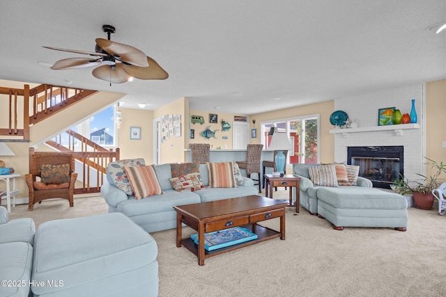 105 Island Quay Ct, Atlantic Beach, NC 28512 - carpeted living room featuring a ceiling fan, a textured ceiling, stairs, and a fireplace