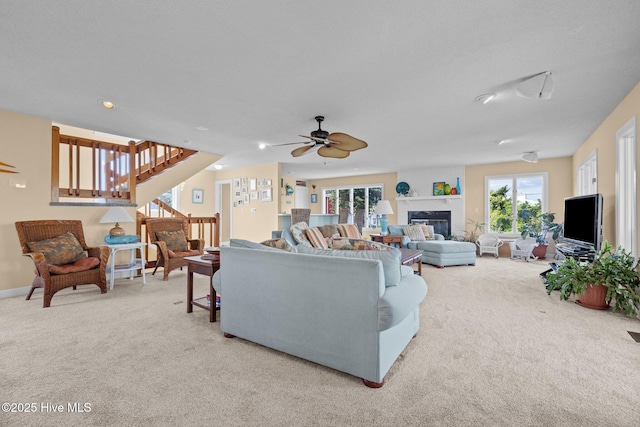 105 Island Quay Ct, Atlantic Beach, NC 28512 - carpeted living room with a glass covered fireplace, a ceiling fan, and stairs