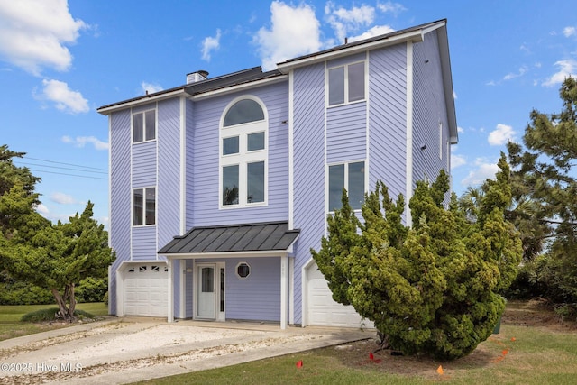 105 Island Quay Ct, Atlantic Beach, NC 28512 - view of front of home with a chimney, a standing seam roof, metal roof, and a garage