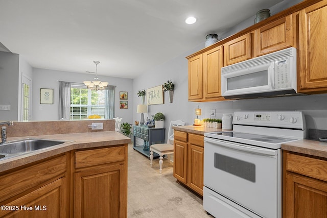 202 Two Oaks Ct, Newport, NC 28570 - kitchen with a sink, a notable chandelier, white appliances, brown cabinetry, and pendant lighting