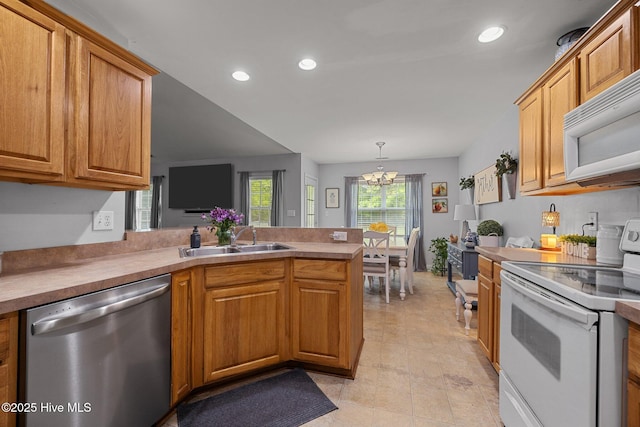 202 Two Oaks Ct, Newport, NC 28570 - kitchen featuring a sink, a chandelier, white appliances, a peninsula, and recessed lighting