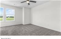 carpeted spare room featuring a ceiling fan