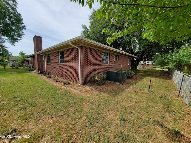 2703 Langston Dr, Goldsboro, NC 27534 - view of home's exterior featuring fence, brick siding, cooling unit, a chimney, and a lawn