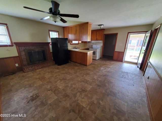 2703 Langston Dr, Goldsboro, NC 27534 - kitchen featuring white electric range, brown cabinetry, a wealth of natural light, and freestanding refrigerator