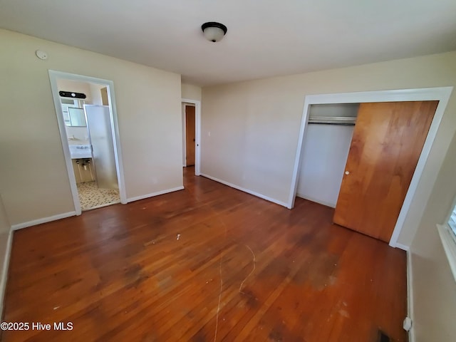 2703 Langston Dr, Goldsboro, NC 27534 - unfurnished bedroom featuring connected bathroom, a closet, baseboards, and wood finished floors