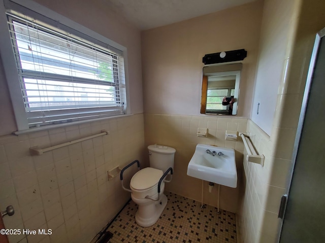 2703 Langston Dr, Goldsboro, NC 27534 - bathroom with toilet, a sink, a wainscoted wall, tile walls, and tile patterned flooring